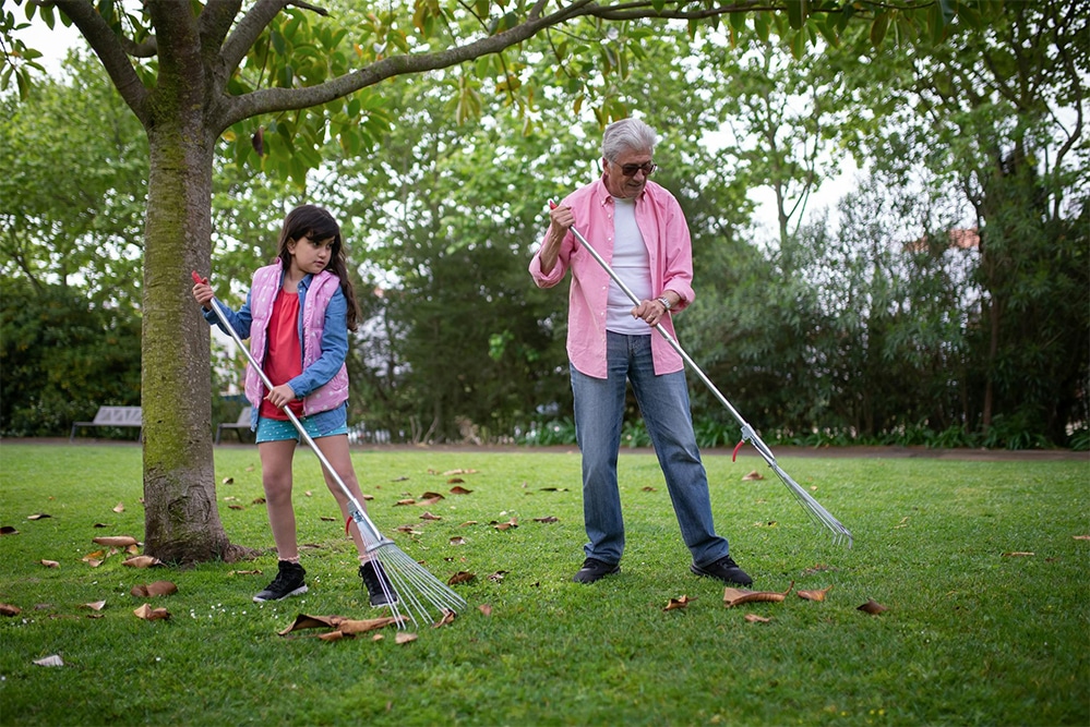 A father and daughter raking leaves